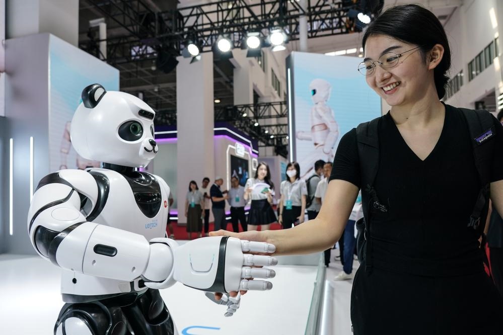 2023年8月16日，一名女士在北京舉辦的2023世界機(jī)器人大會(huì)現(xiàn)場(chǎng)與智能機(jī)器人握手。新華社記者彭子洋攝