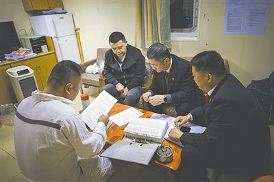 圖②：法官向船長(zhǎng)講解相關(guān)法律規(guī)定，查看船舶資料，并與船方辦理扣押船舶的手續(xù)。