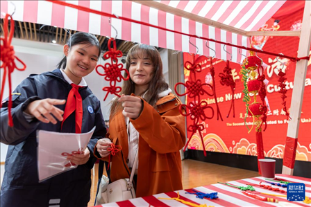 1月28日，復(fù)旦大學(xué)第二附屬學(xué)校學(xué)生（左）為美國(guó)馬斯卡廷中學(xué)學(xué)生（右）介紹中國(guó)結(jié)。 新華社記者 王翔 攝