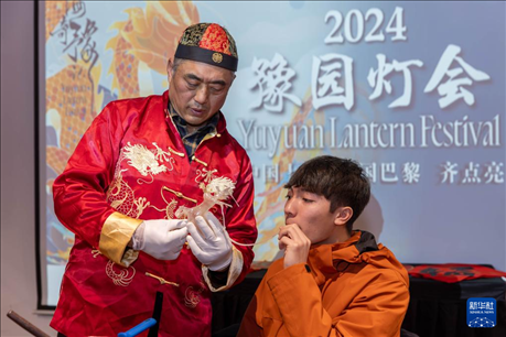 1月28日，在上海豫園舉行的民俗活動(dòng)上，美國(guó)馬斯卡廷中學(xué)學(xué)生在非遺傳承人的指導(dǎo)下吹糖偶。 新華社記者 王翔 攝