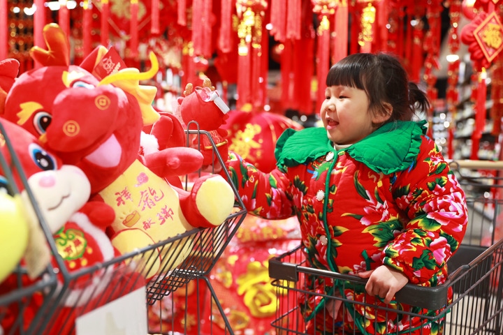 1月23日，在貴州省黔東南苗族侗族自治州岑鞏縣一家超市，小朋友在家人的帶領(lǐng)下選購(gòu)龍年毛絨玩具。新華社發(fā)（唐鵬攝）