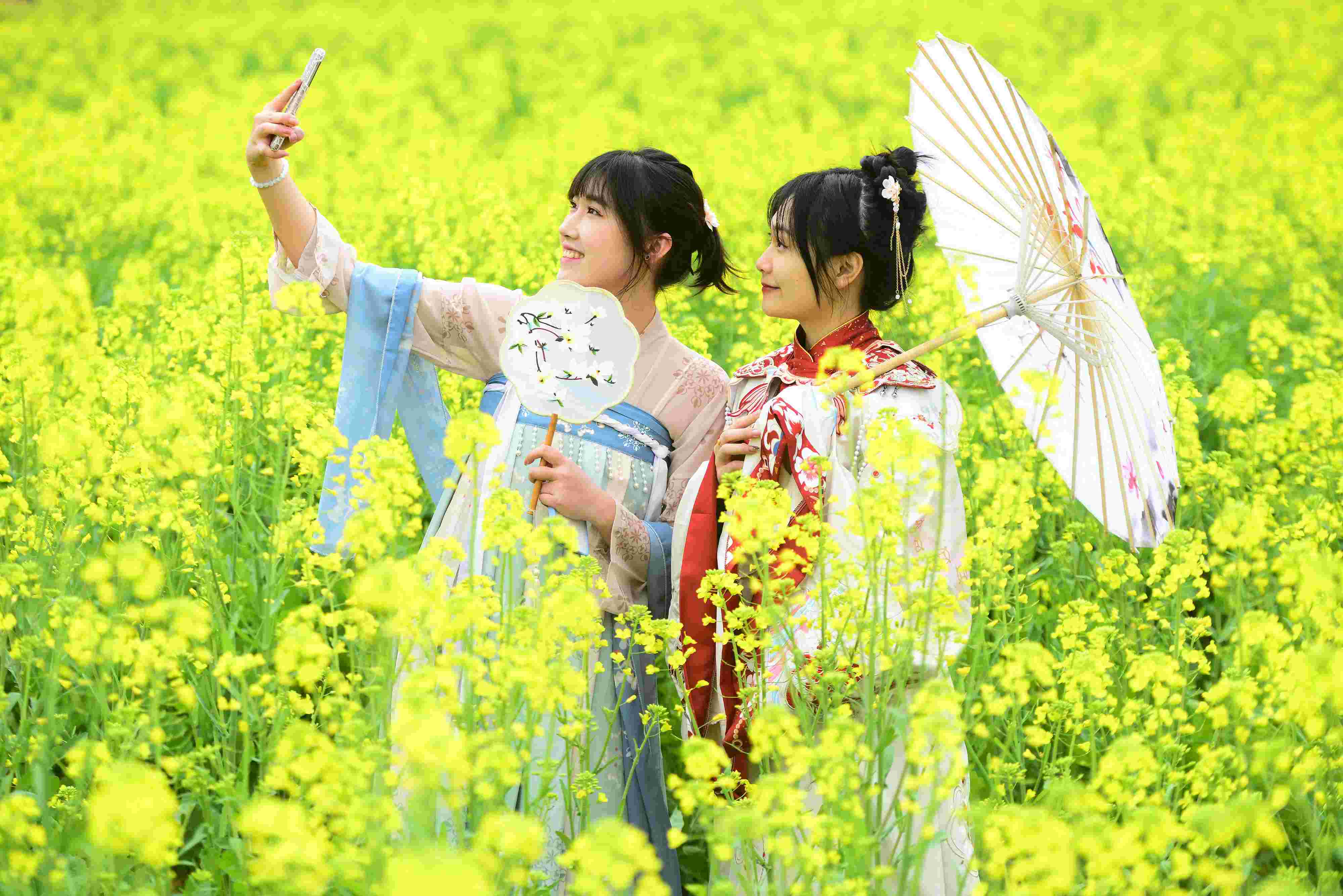 △ 2024年2月16日，廣西賀州，在富川瑤族自治縣麥嶺鎮(zhèn)三民村，游客在油菜花田間賞花拍照。