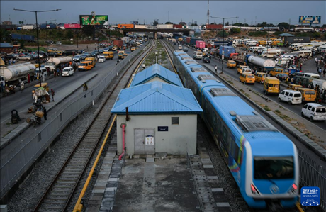 3月4日，在尼日利亞拉各斯，一列輕軌藍(lán)線列車行駛至公路交通擁堵路段附近。新華社記者 韓旭 攝
