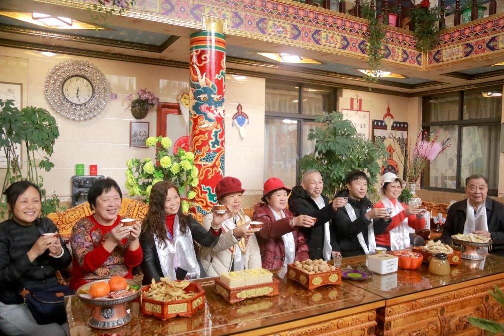 游客們?nèi)胱∶袼藓?，舉杯共飲酥油茶。新華社記者 邱星翔 攝