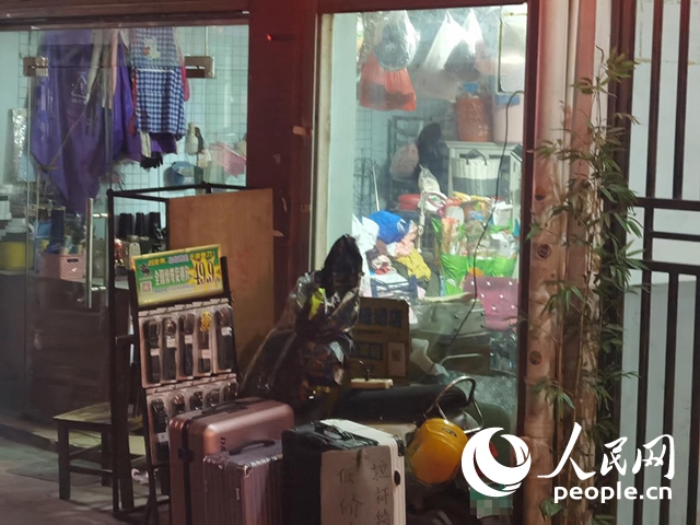南寧“城中村”一裁縫鋪老板將電線從店內(nèi)拉出為電動(dòng)自行車充電。人民網(wǎng) 覃心攝