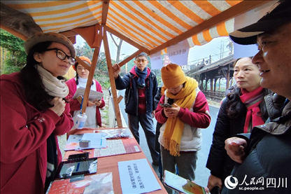 1月6日，“2024成都蒲江柑甜采摘節(jié)”上，記者見(jiàn)到了小萌（左一）和許多年輕人忙著做訪客接待、現(xiàn)場(chǎng)布置、票務(wù)核對(duì)、采摘服務(wù)等工作。人民網(wǎng)記者朱虹攝