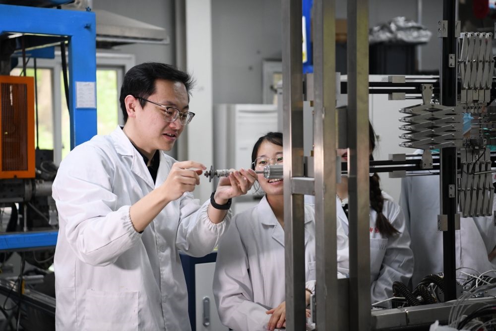 2024年4月6日，在位于安徽合肥的中國科學(xué)技術(shù)大學(xué)，安徽省先進(jìn)功能高分子薄膜工程實(shí)驗(yàn)室團(tuán)隊(duì)成員朱健和（左）在和同事討論實(shí)驗(yàn)設(shè)備的設(shè)計(jì)方案。