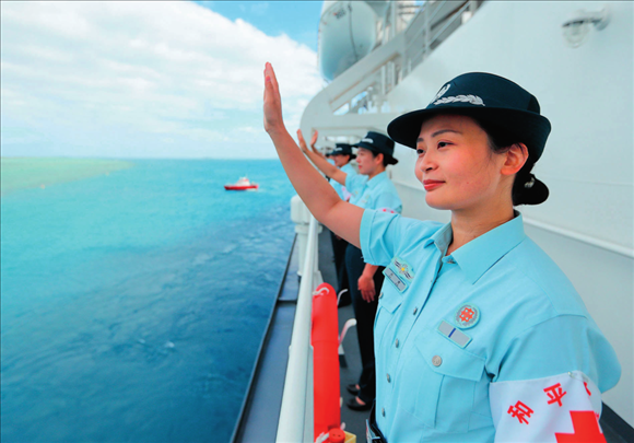 中國(guó)海軍“和平方舟”號(hào)醫(yī)院船結(jié)束訪問(wèn)湯加時(shí)，任務(wù)官兵中的文職人員向歡送人群揮手告別（2023年8月4日攝）。徐巍攝/本刊