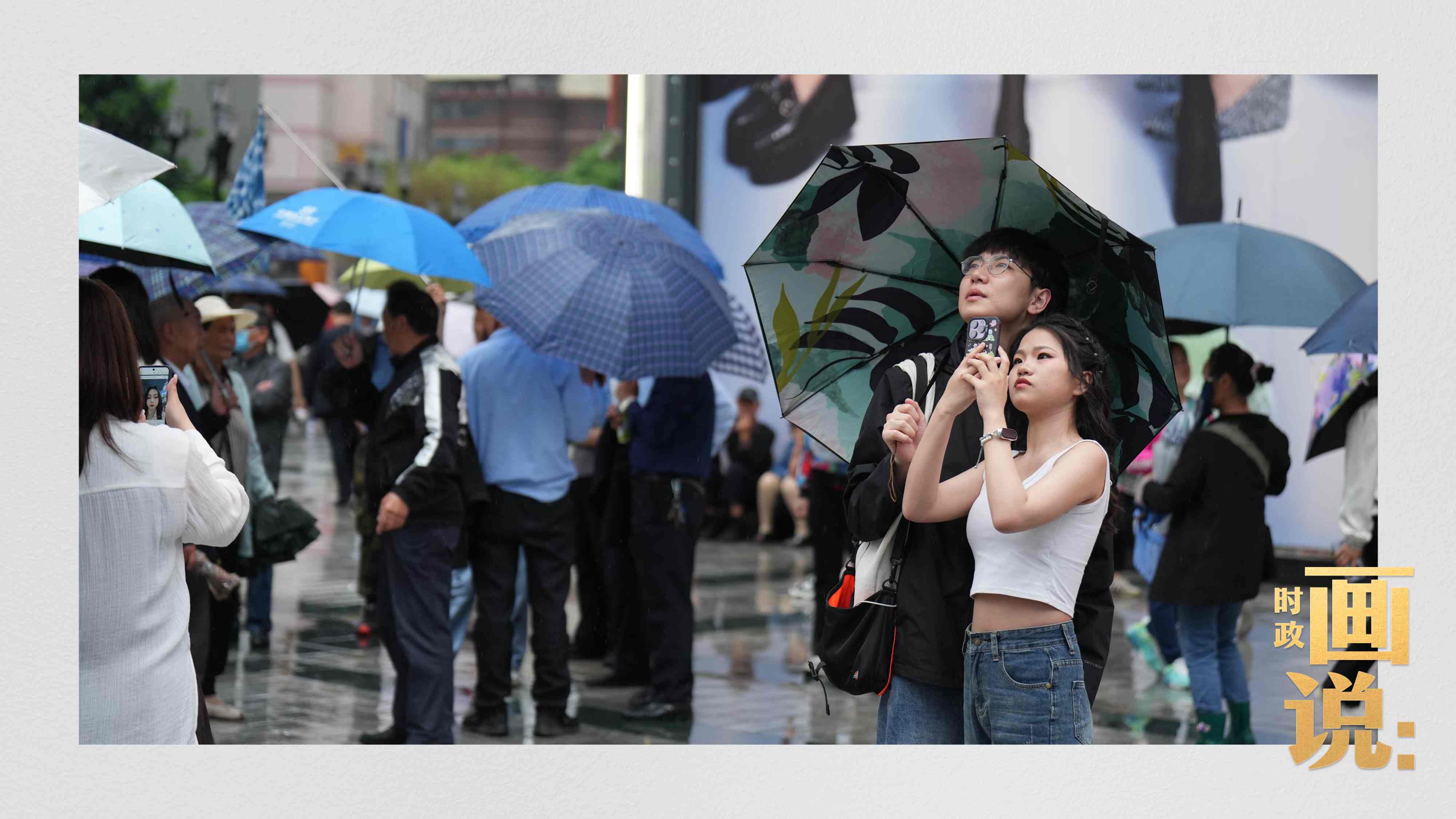 △細(xì)雨中的解放碑步行街，騎在父親肩膀的小女孩好奇張望。
