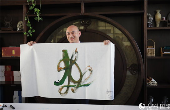 老撾駐華大使館三秘明君參加《五百筆·瀾湄合作》集體藝術(shù)創(chuàng)作。人民網(wǎng)王婧攝。