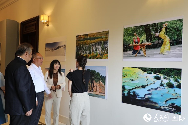 四川省文化和旅游廳副廳長王成平、墨西哥松林文化中心展覽部主任盧西亞·恩里克斯·岡薩雷斯·薩拉維亞、墨西哥中國文化中心主任石岳文參觀圖片展。拍攝者為墨西哥分社外籍雇員埃內斯托·多明戈斯