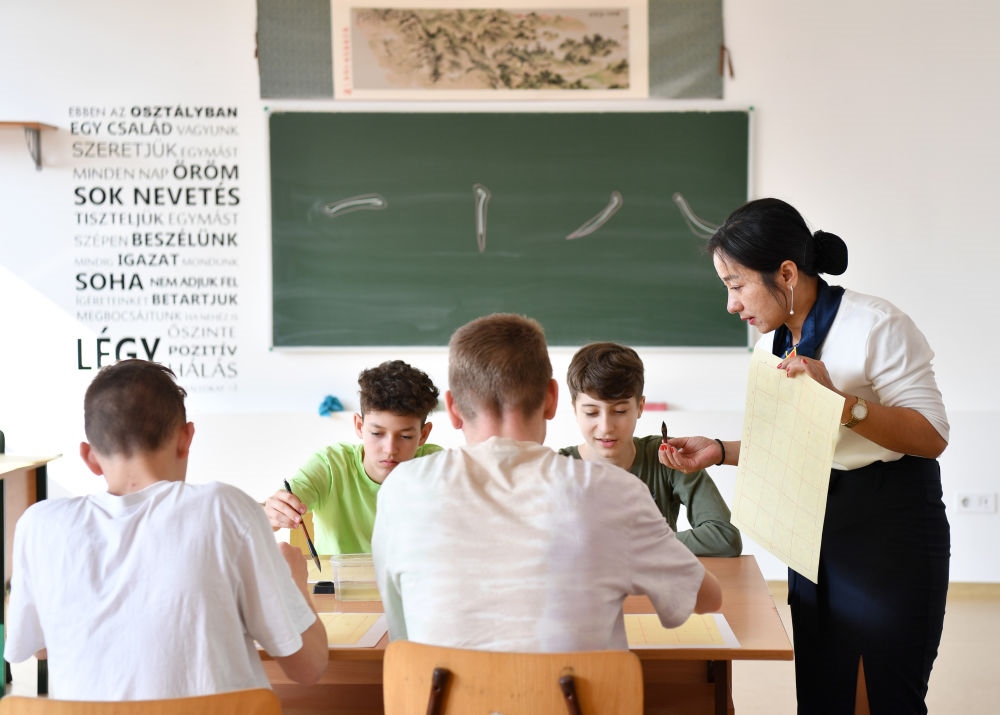 2023年2月24日，在匈牙利首都布達佩斯的匈中雙語學校，中國教師指導學生們學習書法。新華社記者 連漪 攝