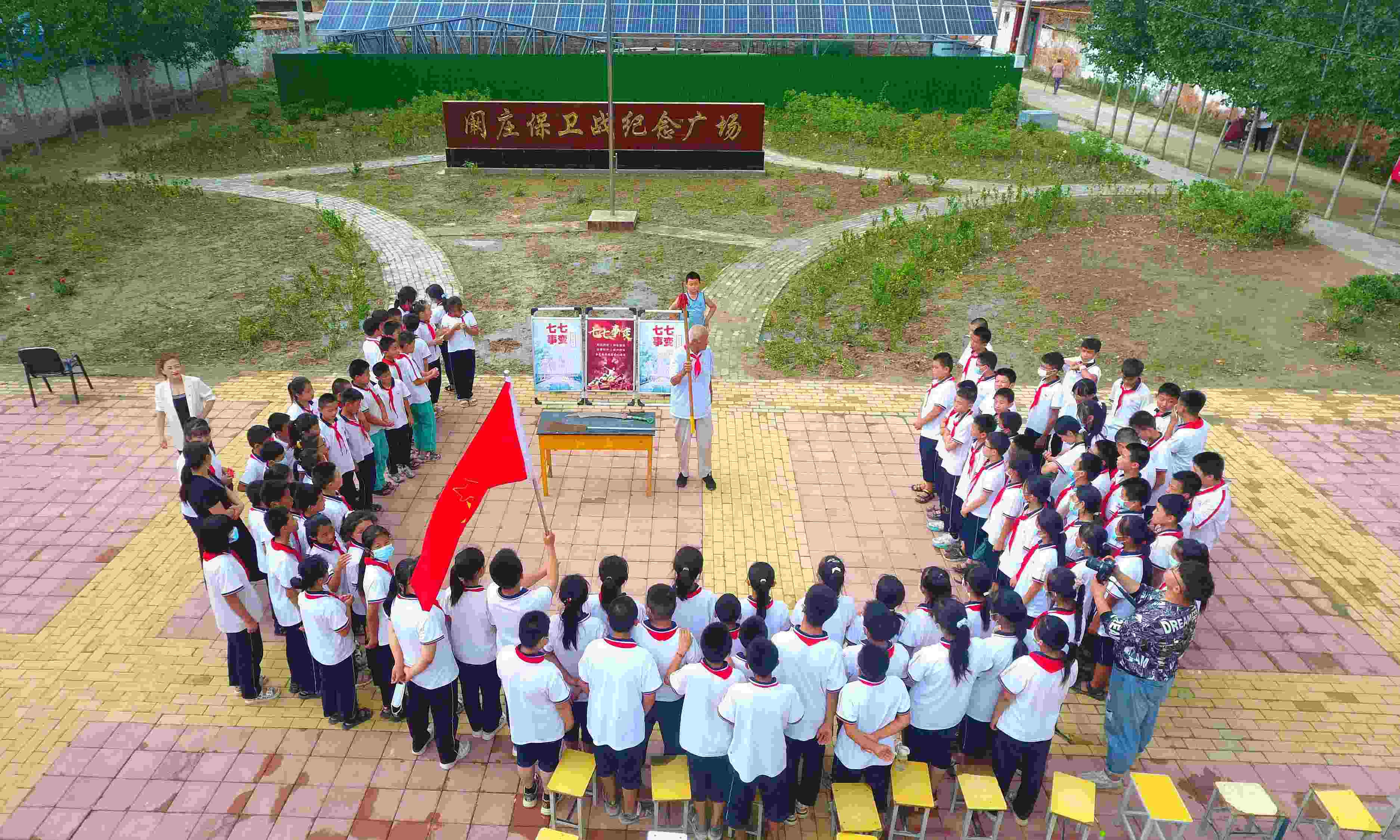 2022年7月6日，山東省聊城市，在茌平區(qū)菜屯鎮(zhèn)闞莊村的闞莊保衛(wèi)戰(zhàn)紀(jì)念廣場，闞莊保衛(wèi)戰(zhàn)親歷者王光木老人為小學(xué)生們講述抗戰(zhàn)故事，展示大刀、長矛。