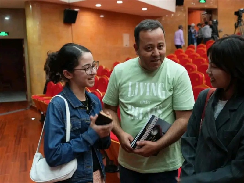 阿爾及利亞市民拉納·艾薩尼和她父親現(xiàn)場聆聽中阿交響樂演出 。蘇州交響樂團(tuán)供圖