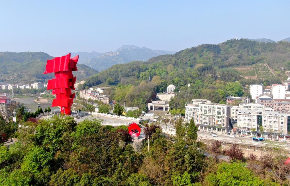 這是2021年4月9日拍攝的鄂豫皖蘇區(qū)首府革命博物館附近的英雄山上的“紅旗飄飄”主題雕塑（無人機(jī)照片）。新華社發(fā)