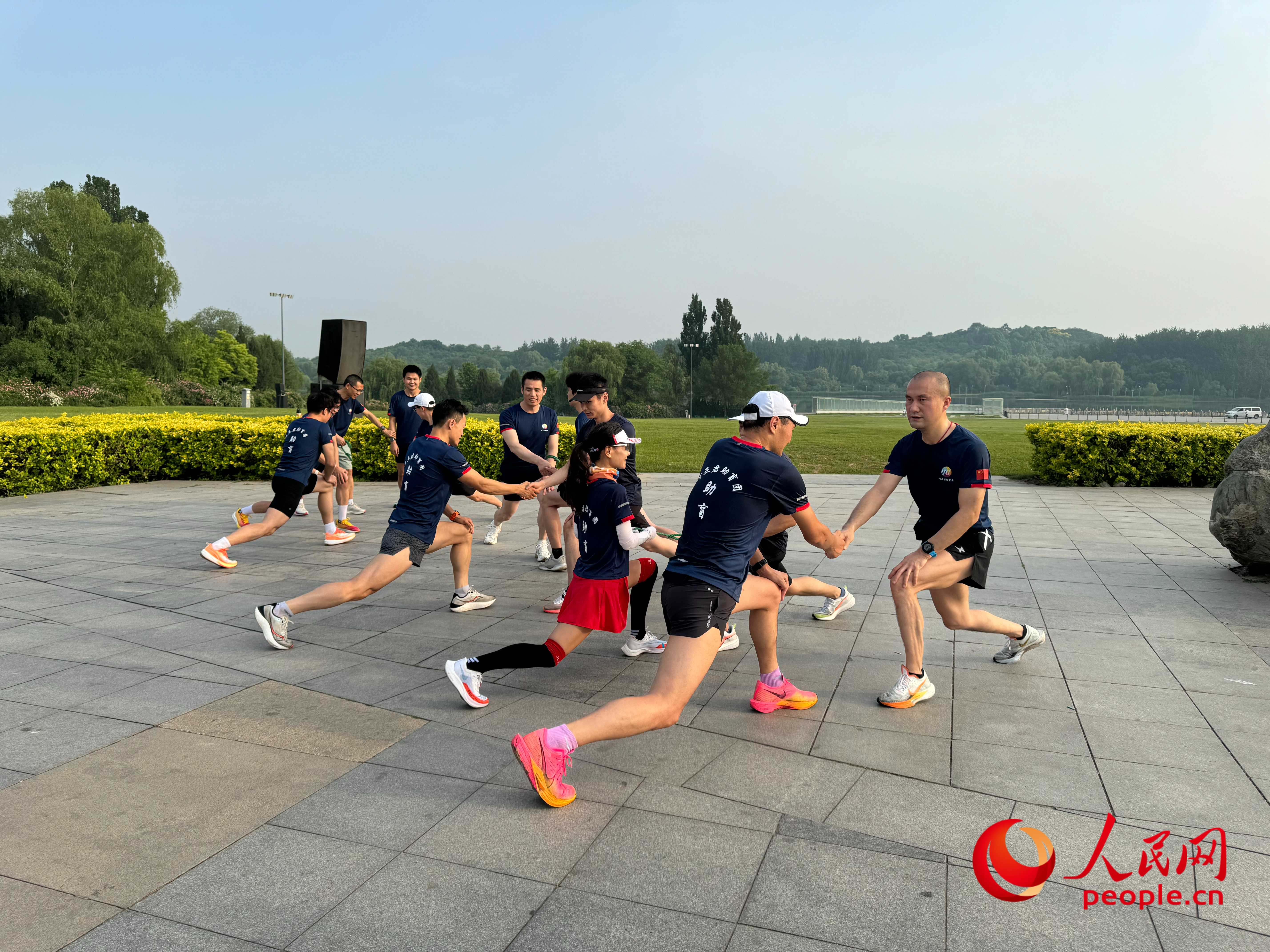 盲人和志愿者做跑步前準(zhǔn)備。人民網(wǎng) 周靜圓攝