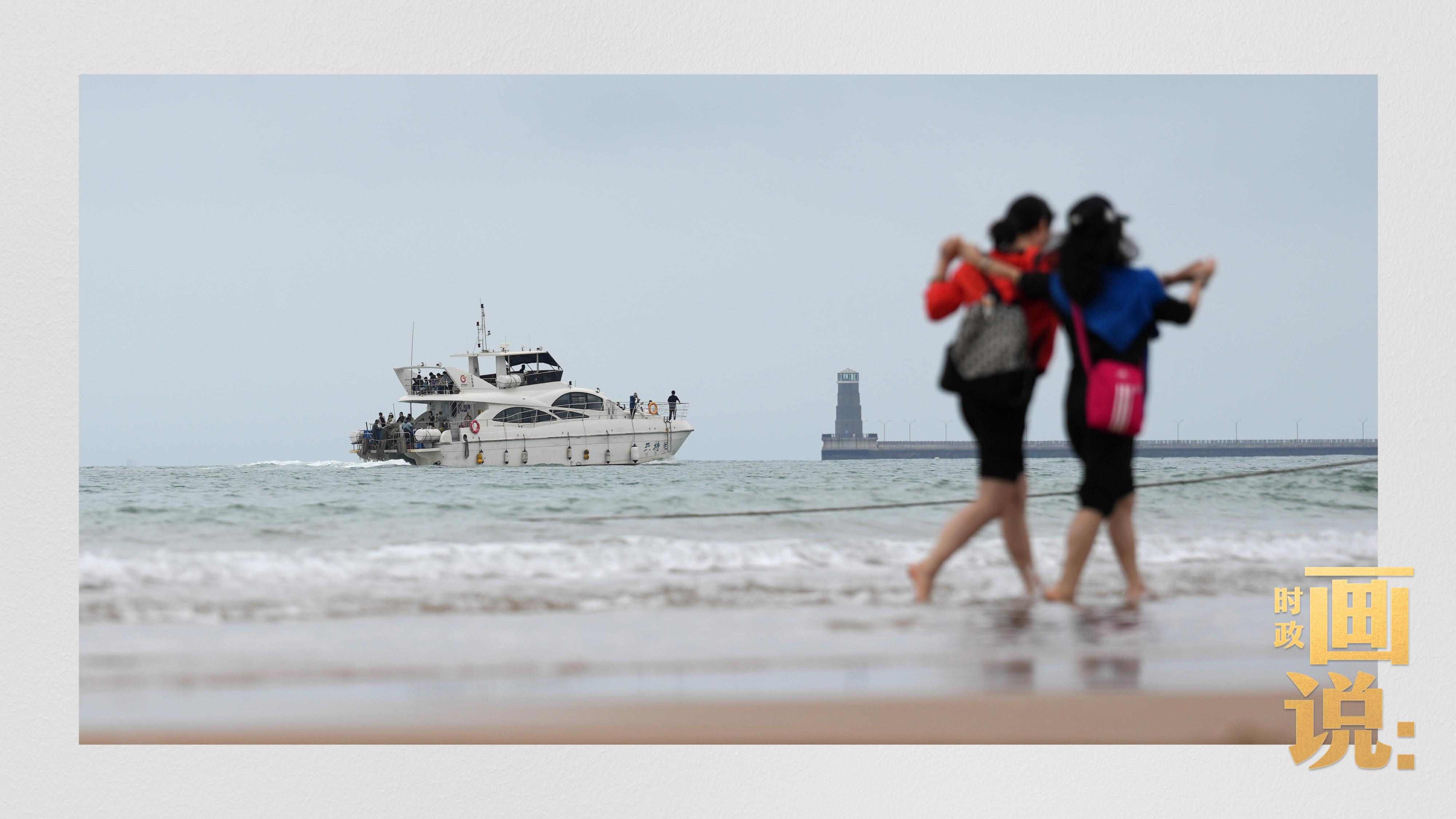 △日照陽光海岸綠道上的萬平口景區(qū)，一對游客在海浪中翩然起舞。