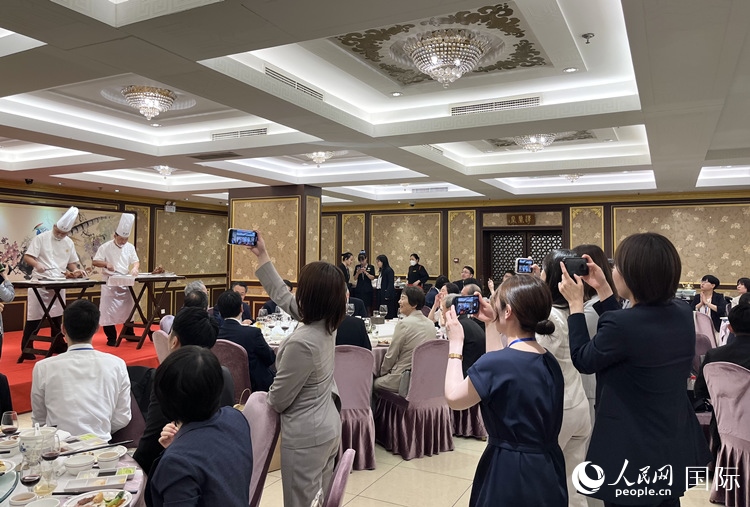 國家級非物質(zhì)文化遺產(chǎn)、全聚德片鴨工藝吸引代表團(tuán)成員拍照留念。