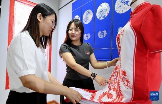 5月31日，在衡水市阜城縣一家剪紙工作室，游客在觀賞帶有剪紙元素的旗袍。