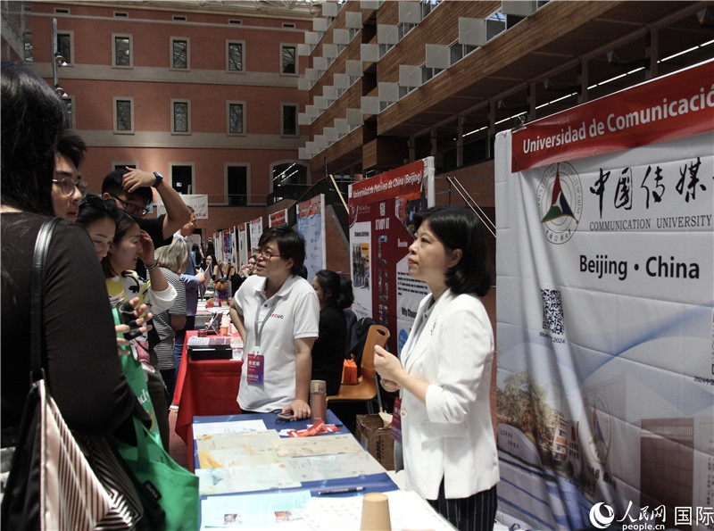 旅西華人華僑在展臺(tái)前咨詢。人民網(wǎng)記者 許海林?jǐn)z