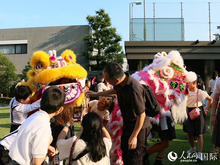 孩子們好奇地圍觀舞獅。人民網(wǎng) 許可攝