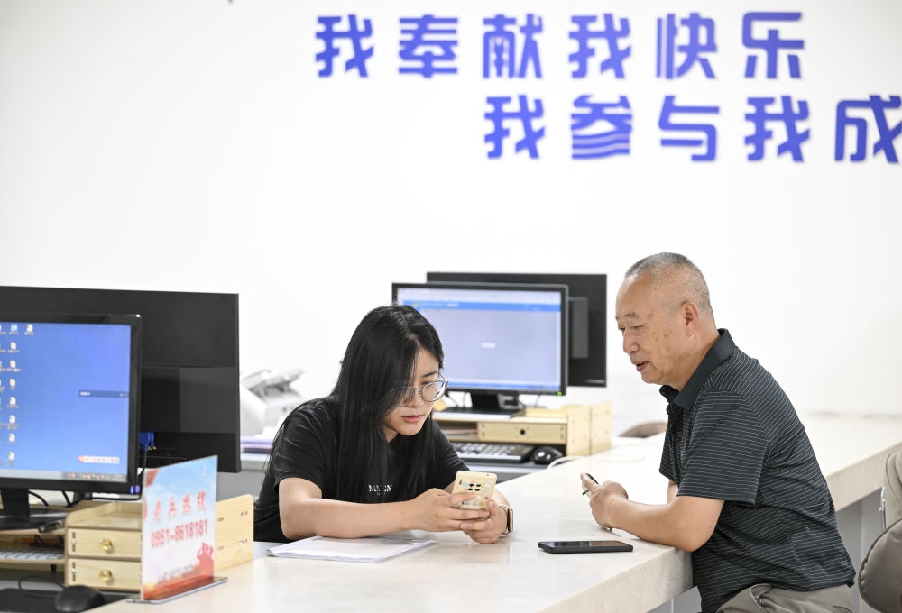 6月20日，在長城花園社區(qū)黨群服務中心，工作人員幫助居民辦理業(yè)務。