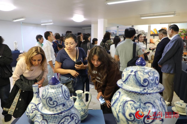 在展覽現(xiàn)場(chǎng)，觀眾們駐足欣賞德化瓷和墨西哥彩瓷。人民網(wǎng) 埃內(nèi)斯托·多明戈斯攝