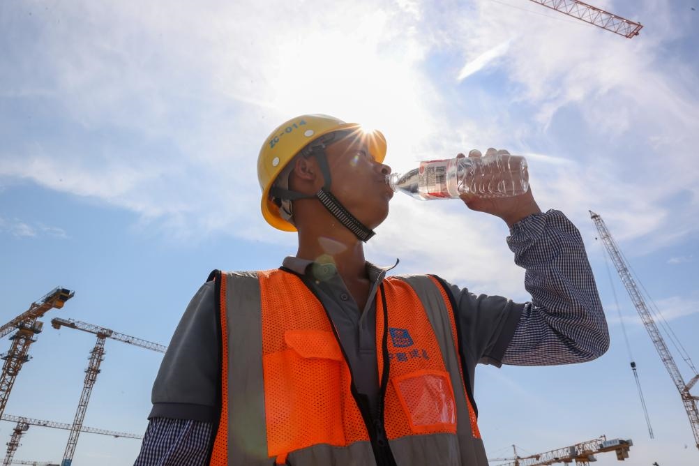 6月18日，在江蘇省無錫市奧體三期項目施工現場，中建二局工人在喝水解暑。新華社發(fā)（朱吉鵬 攝）