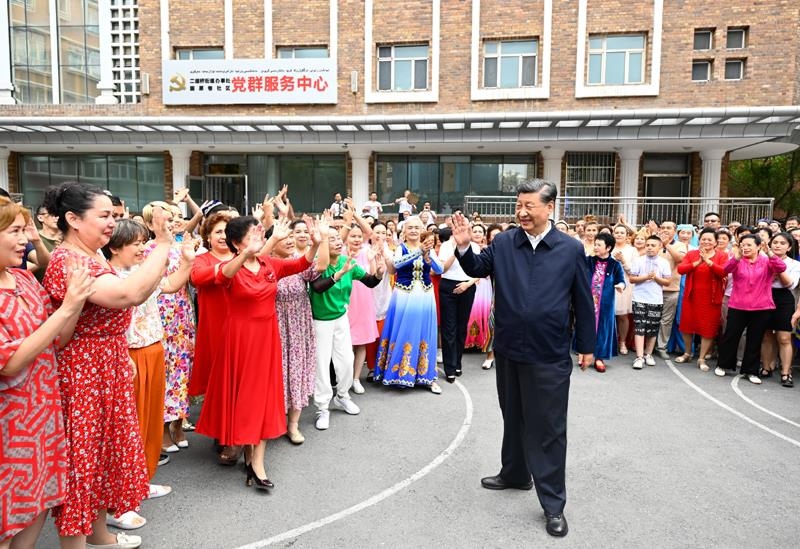 2022年7月13日，習(xí)近平總書記在新疆烏魯木齊市天山區(qū)固原巷社區(qū)考察時，向各族群眾揮手致意。