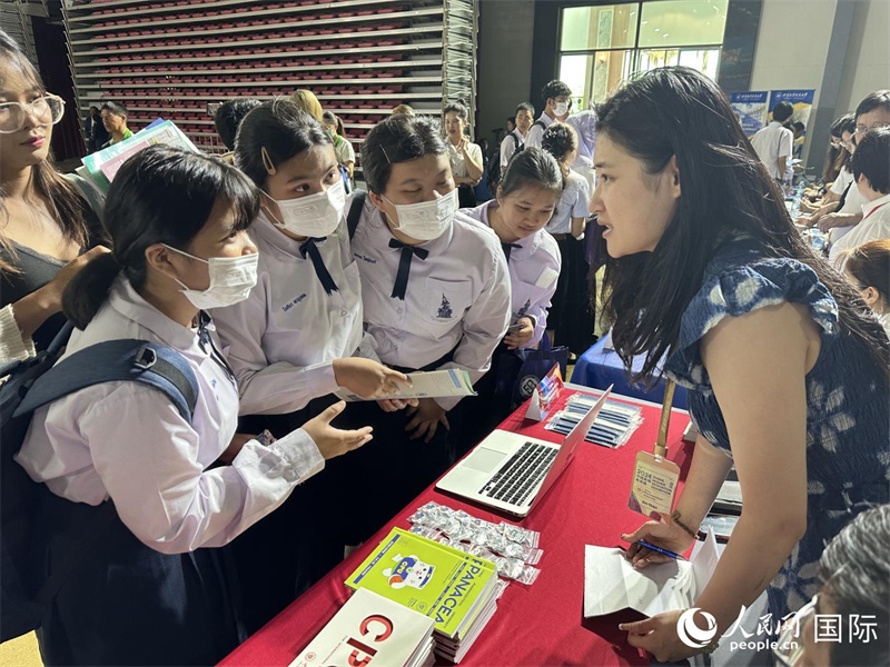 來自泰國的學(xué)生、家長在教育展臺前咨詢。人民網(wǎng)記者 簡承淵攝