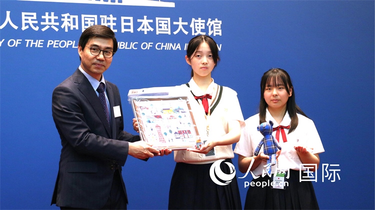 日本小大使向中國駐日本大使館臨時代辦施泳贈送當?shù)靥厣Y品。人民網(wǎng) 許可攝