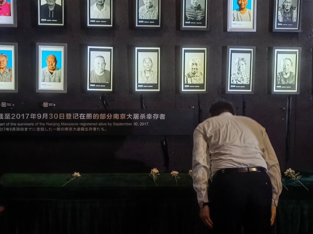 7月18日，人們向離世的南京大屠殺幸存者獻(xiàn)花、鞠躬。新華社記者邱冰清 攝