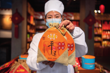 在位于山西省晉中市平遙縣的平遙古城南大街的一家平遙牛肉店內，工作人員展示一款牛肉產品（資料照片）楊晨光攝 / 本刊