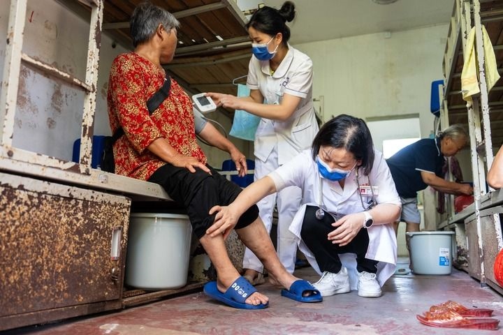 2024年7月30日，在湖南省湘潭縣河口中學(xué)安置點(diǎn)，醫(yī)務(wù)人員為受洪水影響而轉(zhuǎn)移安置的群眾檢查身體。 新華社記者 陳思汗 攝