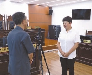 圖為全國人大代表玉明姬（右）詳細(xì)了解環(huán)境資源審判工作情況。劉思妤 攝