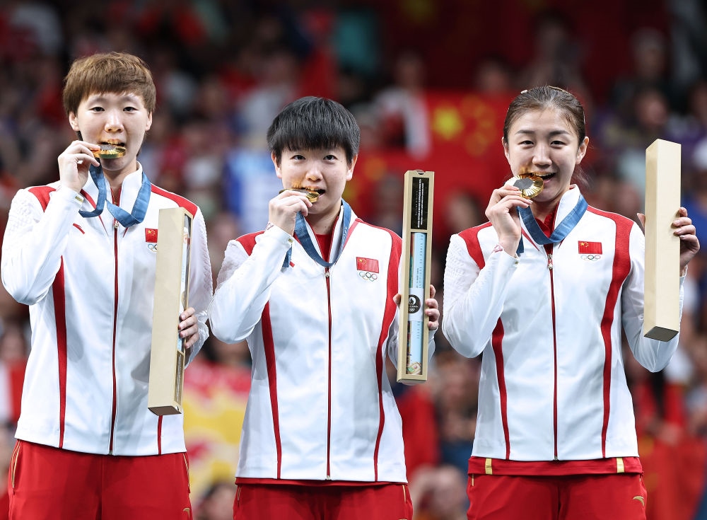 冠軍中國隊選手王曼昱、孫穎莎、陳夢（從左至右）在巴黎奧運(yùn)會乒乓球女子團(tuán)體頒獎儀式上（2024年8月10日攝）。新華社記者 王東震 攝