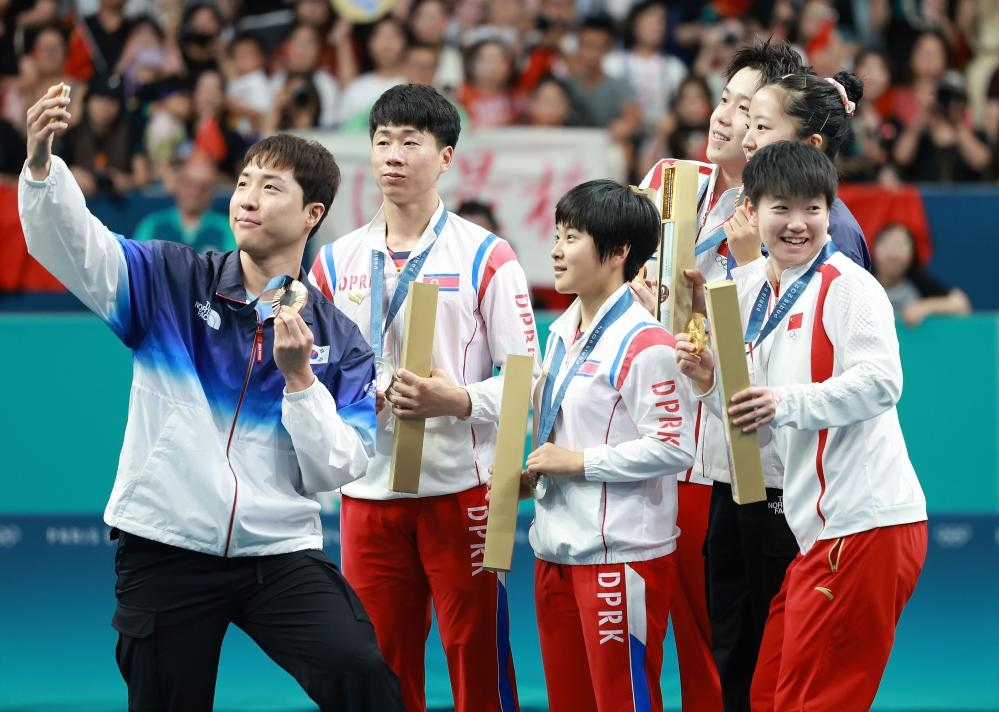 冠軍中國組合王楚欽（右三）/孫穎莎（右一）、亞軍朝鮮組合李正植（左二）/金琴英（左三）、季軍韓國組合林鐘勛（左一）/申裕斌在巴黎奧運(yùn)會乒乓球混雙頒獎儀式上合影（2024年7月30日攝）。新華社記者 劉續(xù) 攝