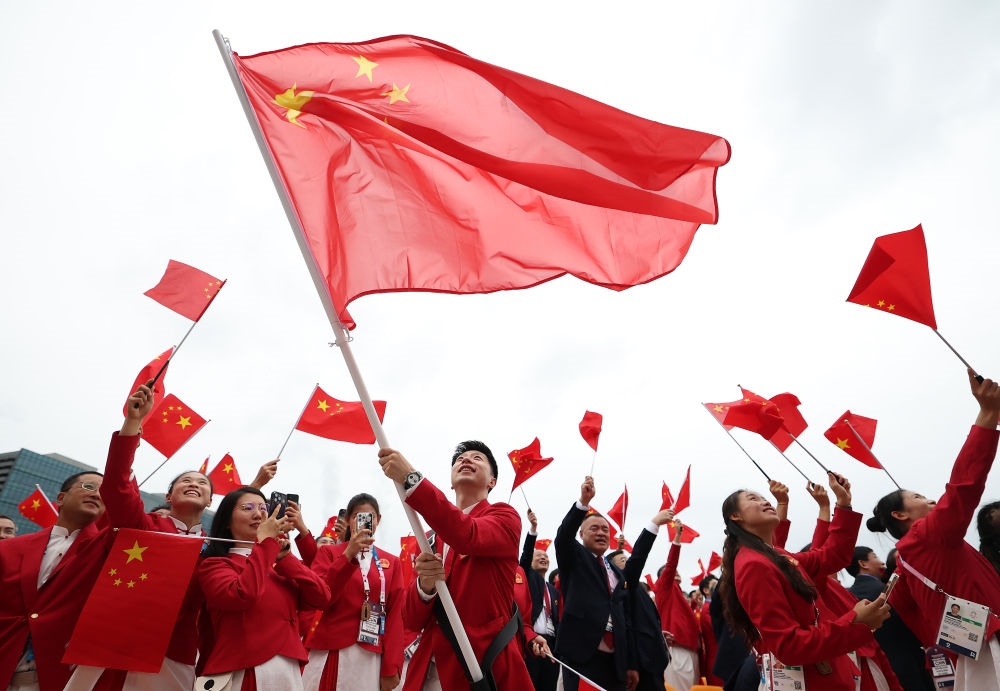 中國體育代表團(tuán)旗手、乒乓球選手馬龍在第33屆夏季奧林匹克運(yùn)動會開幕式前揮舞國旗（2024年7月26日攝）。新華社記者 曹燦 攝