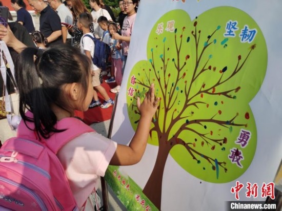 圖為衡水市利民路小學(xué)，孩子們?cè)诔砷L(zhǎng)樹的“好習(xí)慣”樹枝上按手印做出承諾。張松 攝