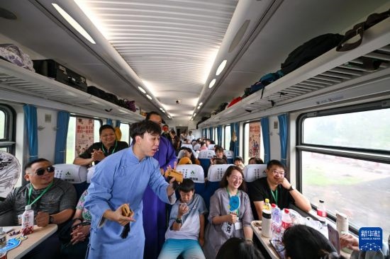 9月7日，相聲演員在S910列車上為旅客表演快板。