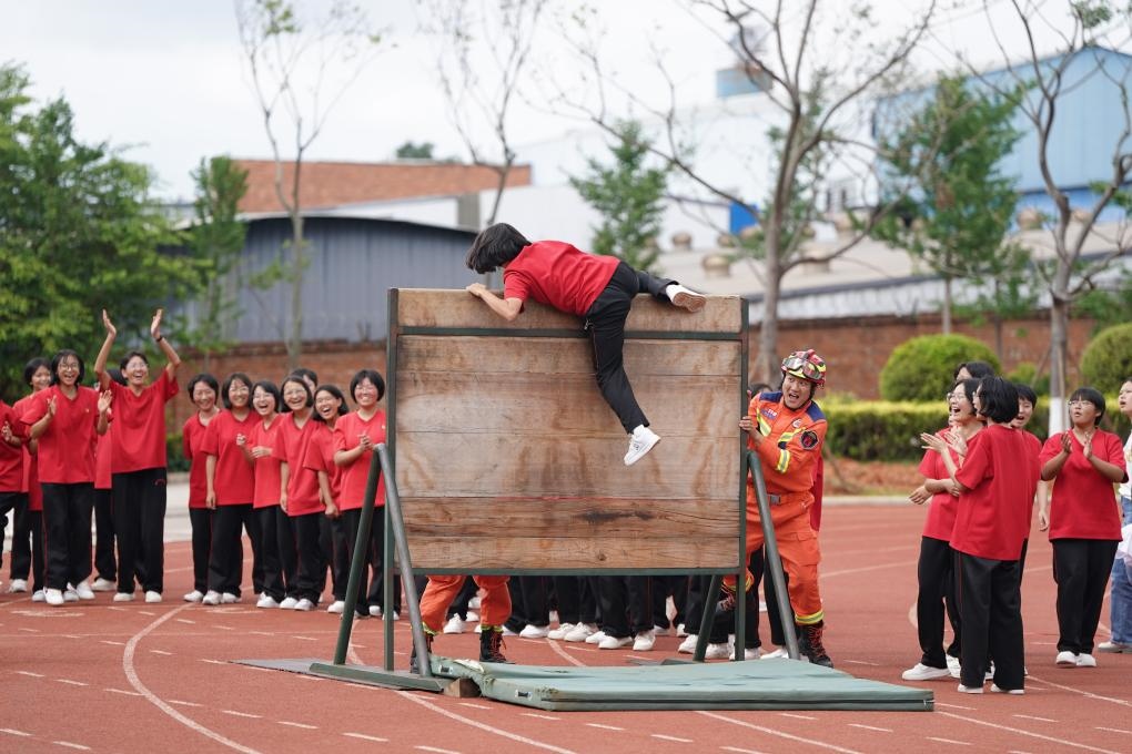 云南麗江華坪女子高級(jí)中學(xué)學(xué)生在體驗(yàn)翻越障礙板。新華社記者陳欣波 攝