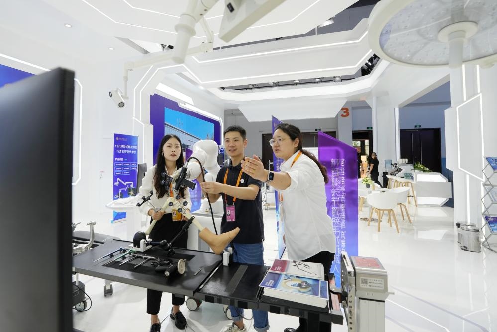 9月11日，一位媒體記者（中）在2024年服貿(mào)會(huì)國家會(huì)議中心會(huì)場體驗(yàn)北京納通科技集團(tuán)有限公司的膝關(guān)節(jié)置換手術(shù)機(jī)器人。新華社記者鞠煥宗 攝