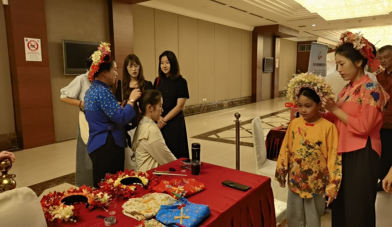 阿拉扎大學(xué)孔子學(xué)院志愿者老師向傳承人學(xué)習(xí)簪花圍。阿拉扎大學(xué)孔子學(xué)院供圖