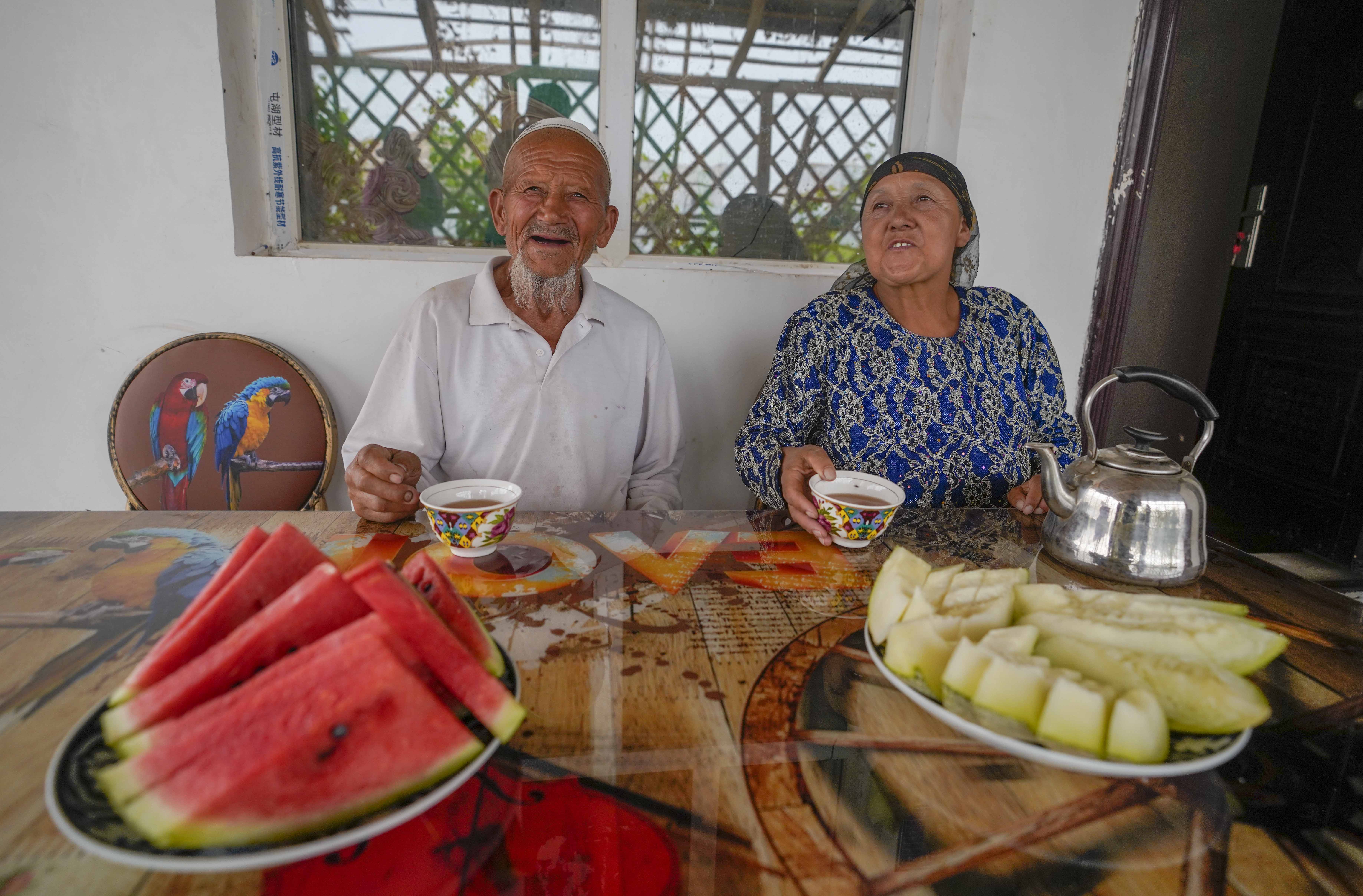 在新疆喀什地區(qū)伽師縣江巴孜鄉(xiāng)依帕克其村57號(hào)，80歲的維吾爾族老人伊米提·艾山（左）在自家庭院中（2020年6月8日攝）。