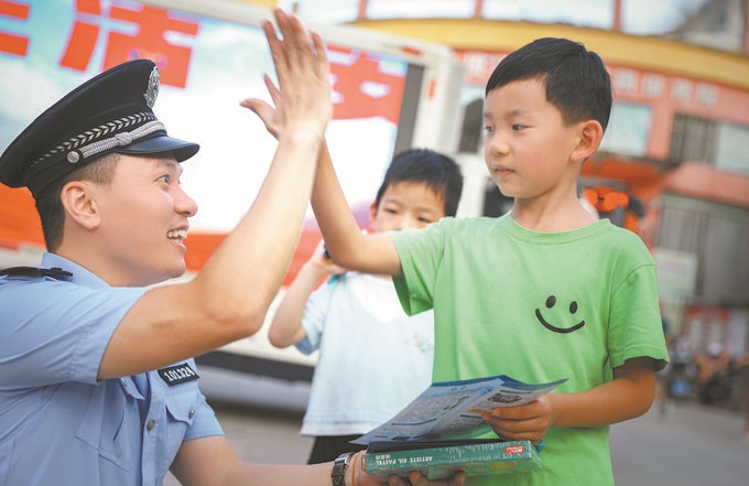▲7月10日，江西省吉安市公安局吉州分局組織民警深入轄區(qū)開(kāi)展安全宣傳，民警向小朋友講解防溺水知識(shí)。朱文杰攝