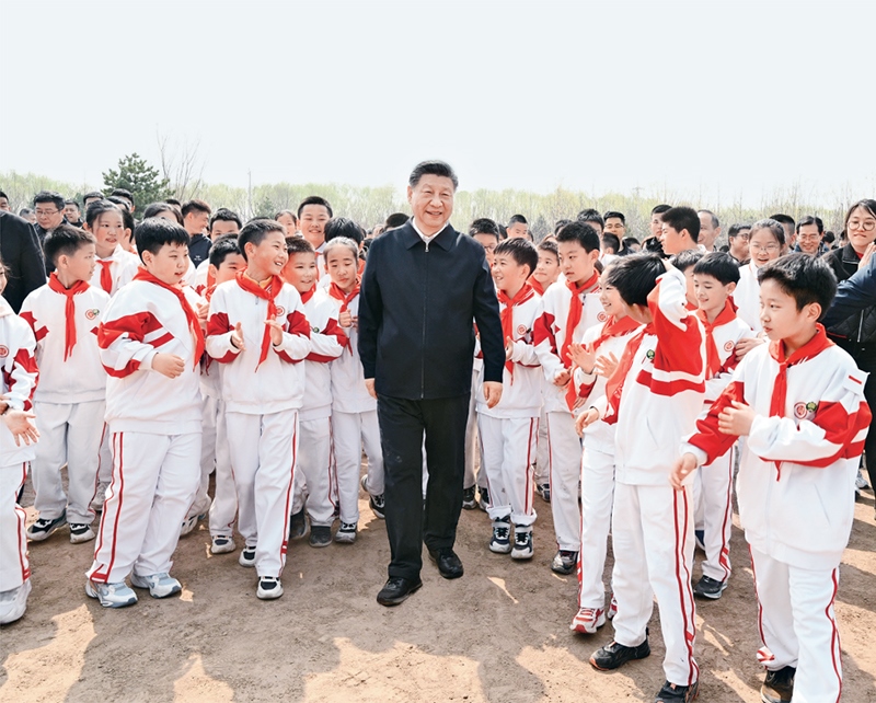 2024年4月3日，黨和國家領(lǐng)導(dǎo)人習(xí)近平、李強、趙樂際、王滬寧、蔡奇、丁薛祥、李希、韓正等來到北京市通州區(qū)潞城鎮(zhèn)參加首都義務(wù)植樹活動。這是習(xí)近平同少先隊員在一起。 新華社記者 李學(xué)仁/攝