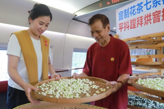 10月1日，福州市茉莉花茶窨制工藝代表性傳承人張子建與旅客在G1634次列車上制作茉莉花茶。新華社記者周義 攝