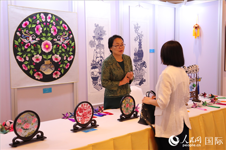 青海非遺文化傳承人向嘉賓介紹展品。人民網實習生姚欣可攝