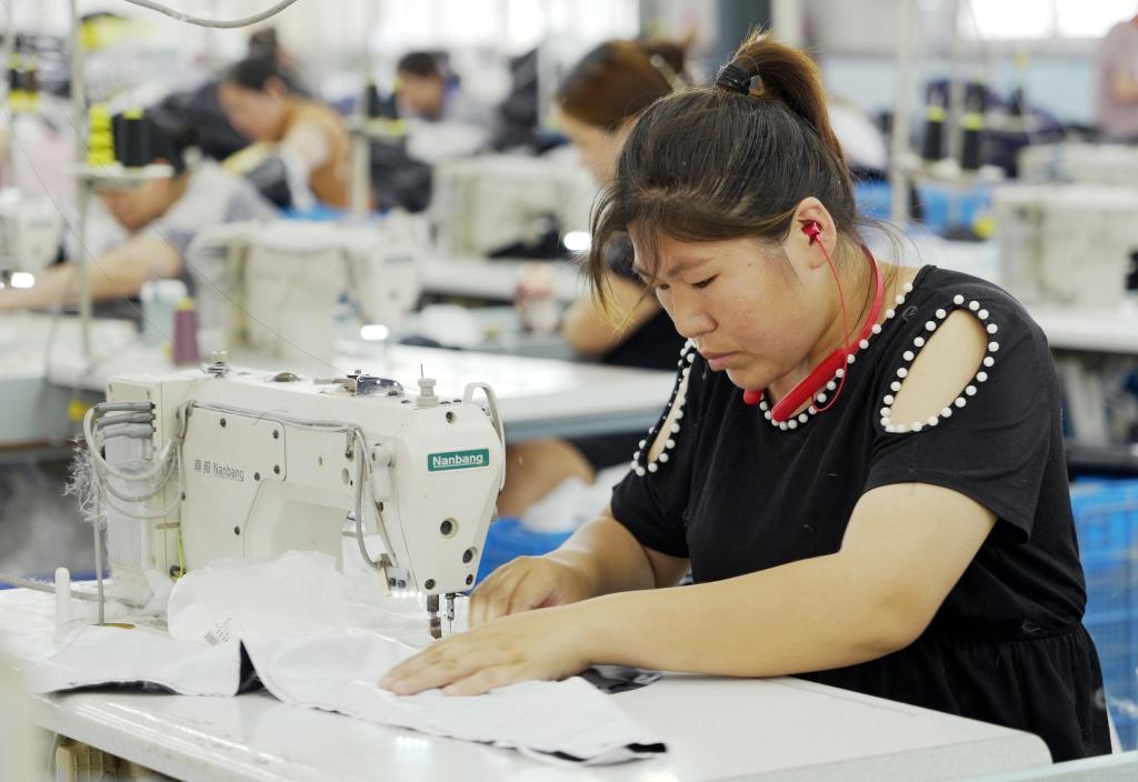 5月20日，村民在李寨村服裝加工廠內(nèi)忙碌。河南省周口市沈丘縣馮營鎮(zhèn)李寨村地處豫東平原。近年來，乘著脫貧攻堅與鄉(xiāng)村振興政策的東風(fēng)，李寨村積極探索產(chǎn)業(yè)發(fā)展模式，通過“龍頭企業(yè)+村集體經(jīng)濟(jì)+農(nóng)戶”的方式，逐漸發(fā)展形成肉牛養(yǎng)殖、設(shè)施農(nóng)業(yè)、服裝加工、康養(yǎng)民宿等產(chǎn)業(yè)，以產(chǎn)業(yè)振興助力鄉(xiāng)村振興。新華社記者 李嘉南 攝