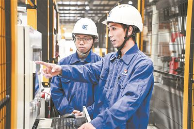 在廣西柳工機(jī)械股份有限公司生產(chǎn)車間內(nèi)，一名高級(jí)技師（右）給徒弟講解數(shù)控設(shè)備操作細(xì)節(jié)。新華社記者 曹祎銘攝